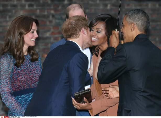 … le prince Harry a planté un baiser sur la joue de Michelle Obama, tandis que le président tenait le parapluie