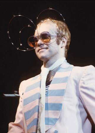 Elton John en concert dans les années 70. Costume plus sobre, mais il se rattrape avec les lunettes