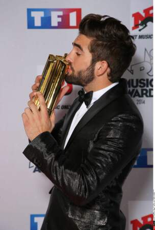 Kendji embrasse l'un des deux trophées qu'il a remporté lors de cette soirée des NRJ Music Awards
