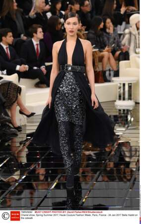 Bella Hadid, très chic dans une robe noire ceinturée et des chaussures à paillettes.  