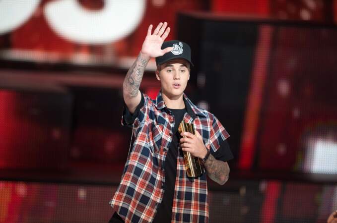 2015, Justin Bieber, casquette et bras tatoués, salue le public
