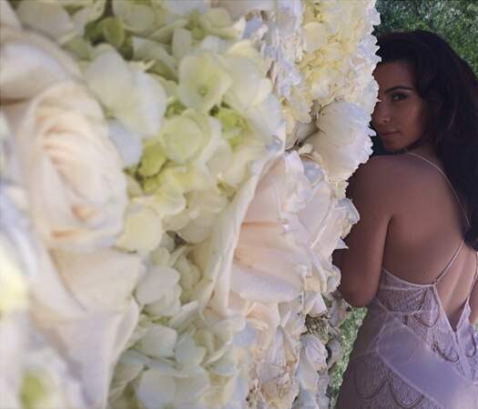 Voici ensuite Kim Kardashian, qui joue à cache-cache derrière son tapis de roses géant, un cadeau de Kanye 