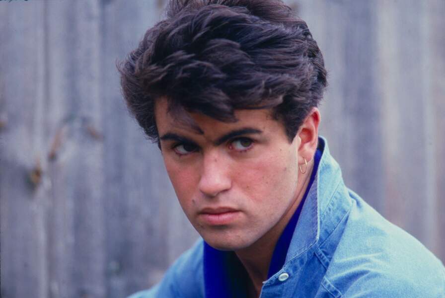 Boucles d'oreilles et brushing : le look signature de George Michael dans les années 80. 