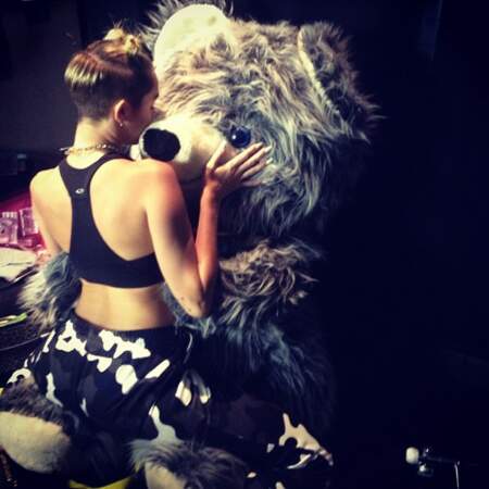 Miley qui fait des bisous à un ours en peluche géant. Tout va bien !