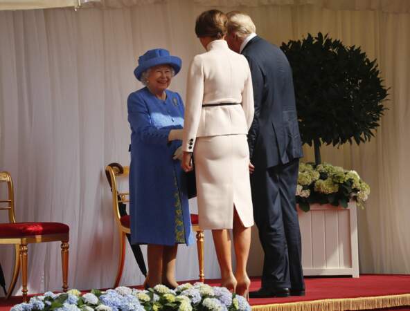 Tout sourire, la reine d'Angleterre serre les mains de ses invités