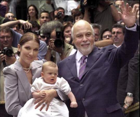 Dans son costume de baptême, entre Céline Dion et son père René Angélil en 2001
