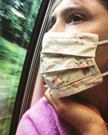 Bérengère Krief, pensive dans le train derrière son joli masque à fleurs