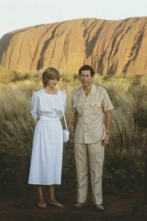Le prince Charles et Diana photographiés ensemble devant Uluru Ayers Rock près d'Alice Springs lors de leur visite royale en Australie le 21 mars 1983. Charles porte un costume saharien et Diana une robe blanche immaculée qui contraste avec les dunes de sable.