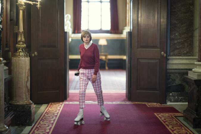Un pull uni et un pantalon à carreaux vichy roses que l'on retrouve lorsque Diana traverse les couloirs de Buckingham en Rollers. Ce qu'avait réellement fait la princesse Diana.