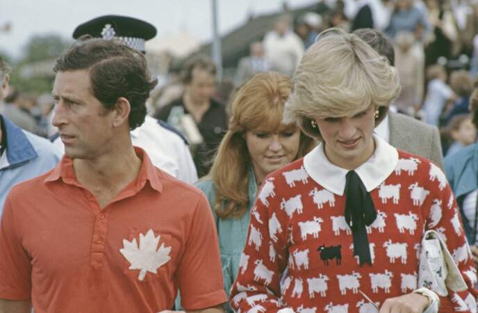 Diana assiste a un match de polo du prince Charles au au Smith's Lawn, Guards Polo Club, Windsor, en juin 1983. Diana porte un pull "mouton noir" Muir and Osborne. On a souvent interprété cela comme une façon d'exprimer qu'elle se sentait comme le vilain petit canard de la famille royale.