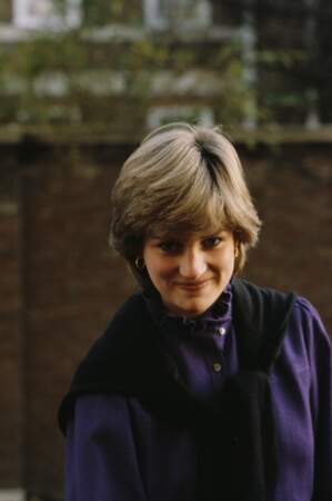Diana, encore insouciante, sourit malicieusement dans un pull violet.