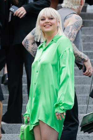 Carré blond platine et chemise néon, Louane détonne au défilé AMI en juin 2022 à Paris.