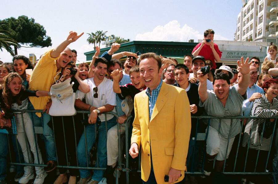 Autre année à Cannes, autre look. Le costume jaune de l’animateur de TF1 fait fureur sur la Croisette en 1999 !