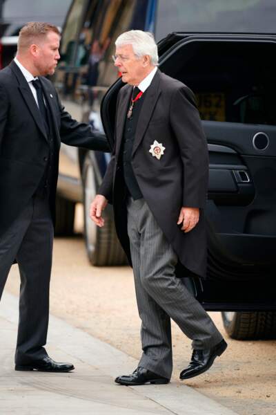L'ancien premier ministre John Major descend de sa voiture d'un air solennel 