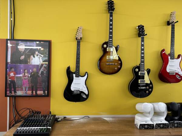 On passe dans la salle de répétitions, avec guitares et photos souvenirs sur les murs