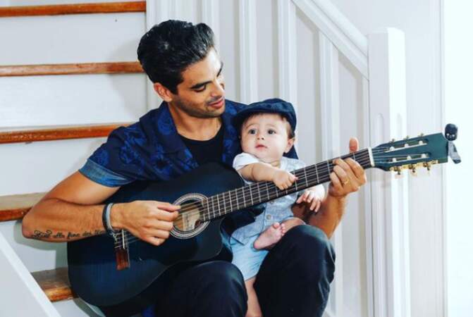 Christophe Licata prend la pose avec son fils et sa guitare.