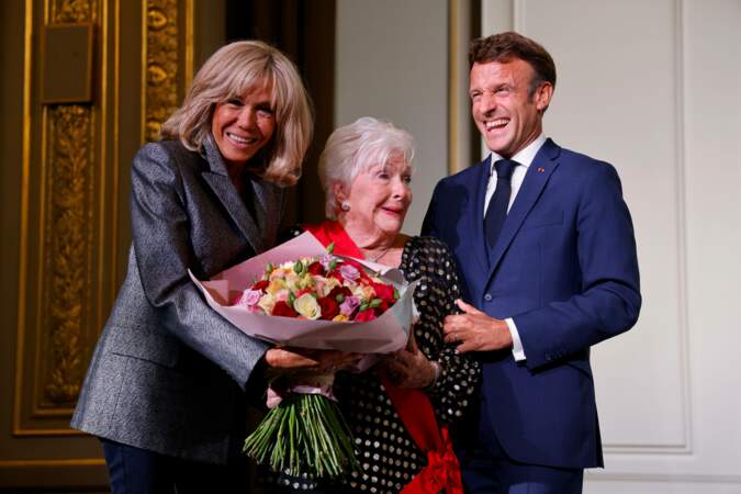 Brigitte et Emmanuel Macron hilares autour de Line Renaud, ravie d'avoir été décorée de la Grand-croix de la Légion d'honneur, le 2 septembre 2022