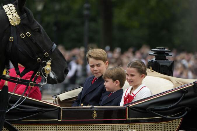 De gauche à droite : le prince George, le Prince Louis et la princesse Charlotte quittant Buckingham Palace en calèche pour se rendre à la parade Trooping The Colour.