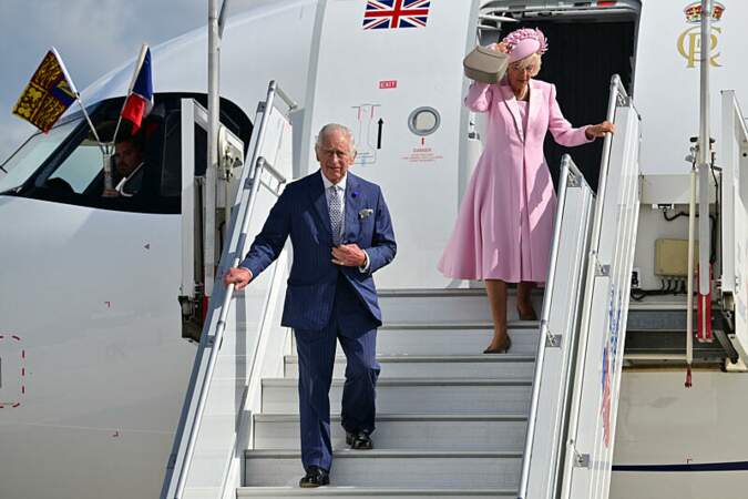 Dès leur arrivée, la reine consort a eu quelques difficultés avec son splendide chapeau à cause du vent...