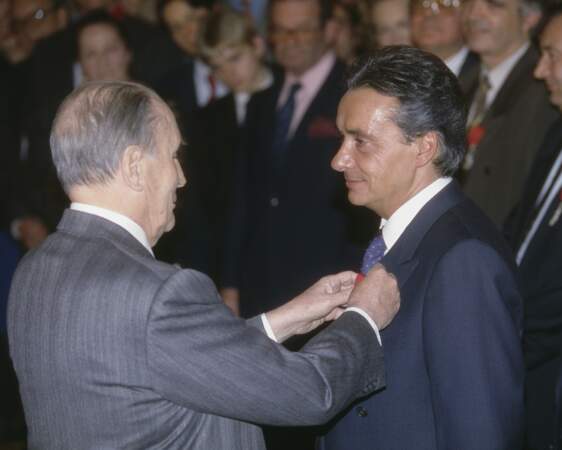 Michel Sardou reçoit la médaille de Chevalier des Arts et des Lettres de la main du président François Mitterand en 1993.