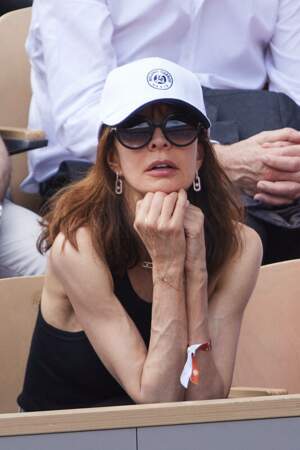 Anne Parillaud, casquette vissée sur la tête, dans les tribunes de Roland-Garros